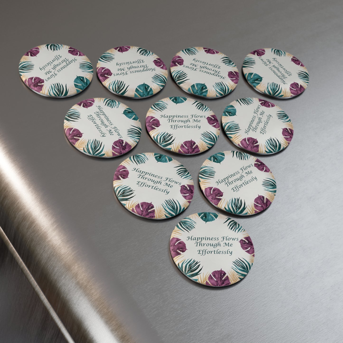 Set of round pins with floral design and text on a metallic surface