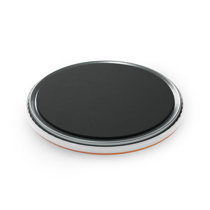 Black circular object with metallic rim on a white background