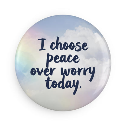 Button badge with 'I choose peace over worry today' text on a sky background
