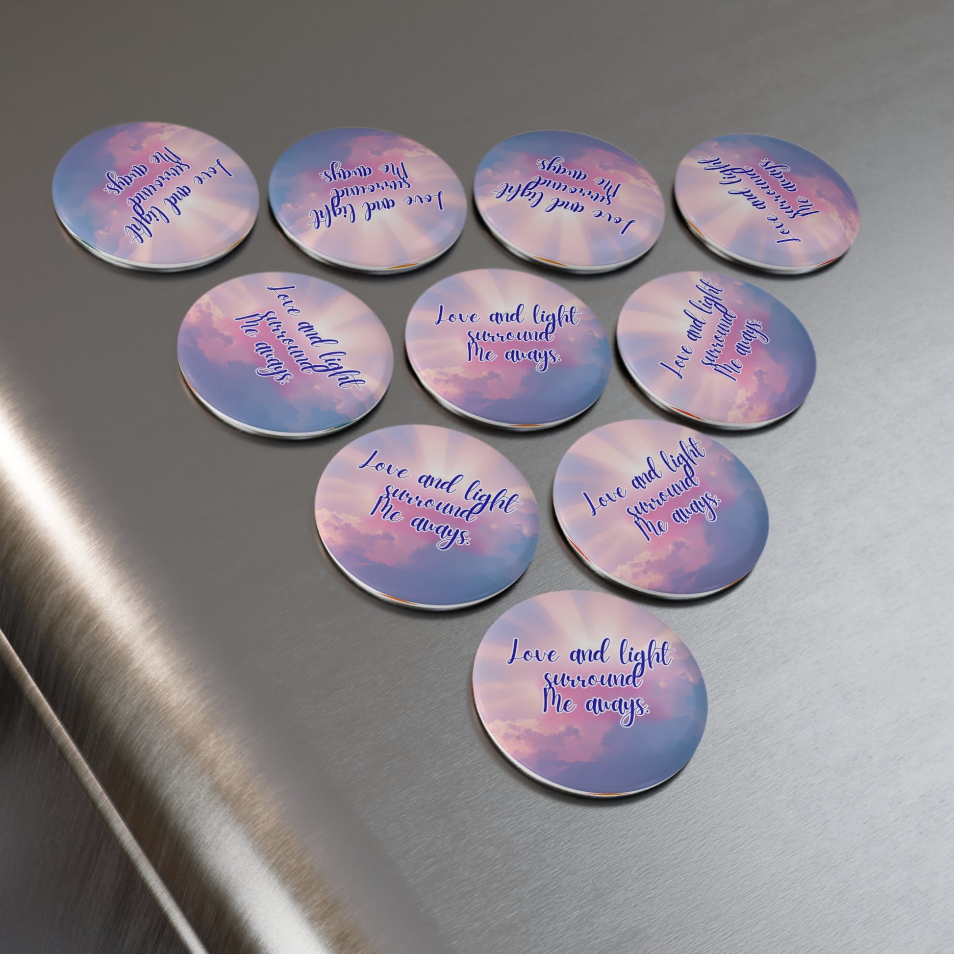 Set of circular pins with motivational phrases on a metallic surface